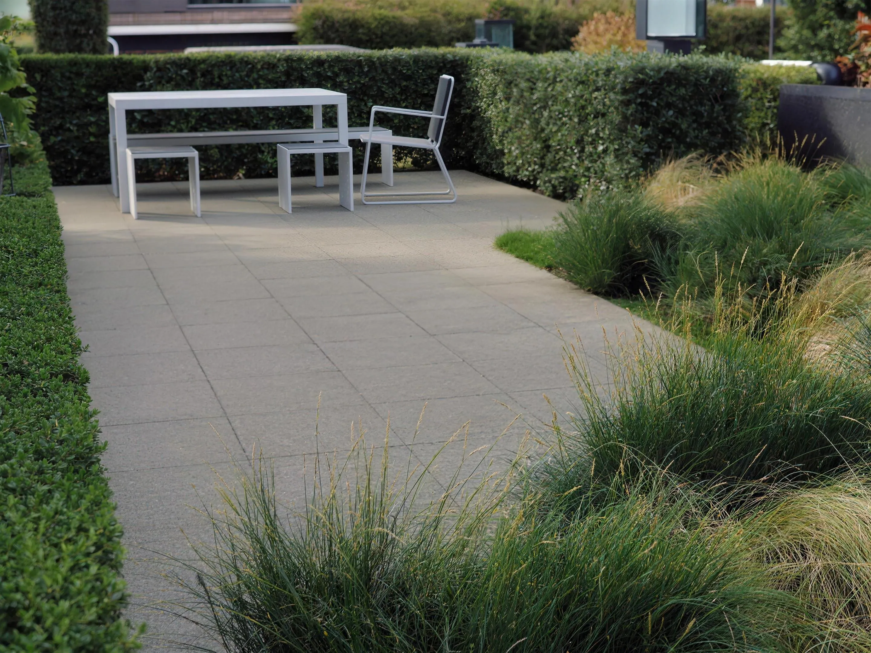 Moderne strakke tuin — Moderne strakke tuin met rechte lijnen, weinig onderhoud en veel zit- en loopruimte, daglicht.